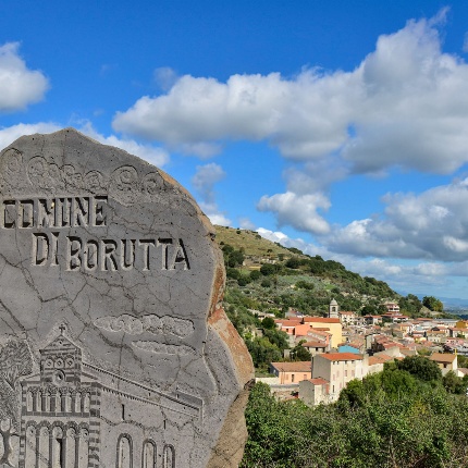 Stele decorata e veduta del paese (foto Ivo Piras)