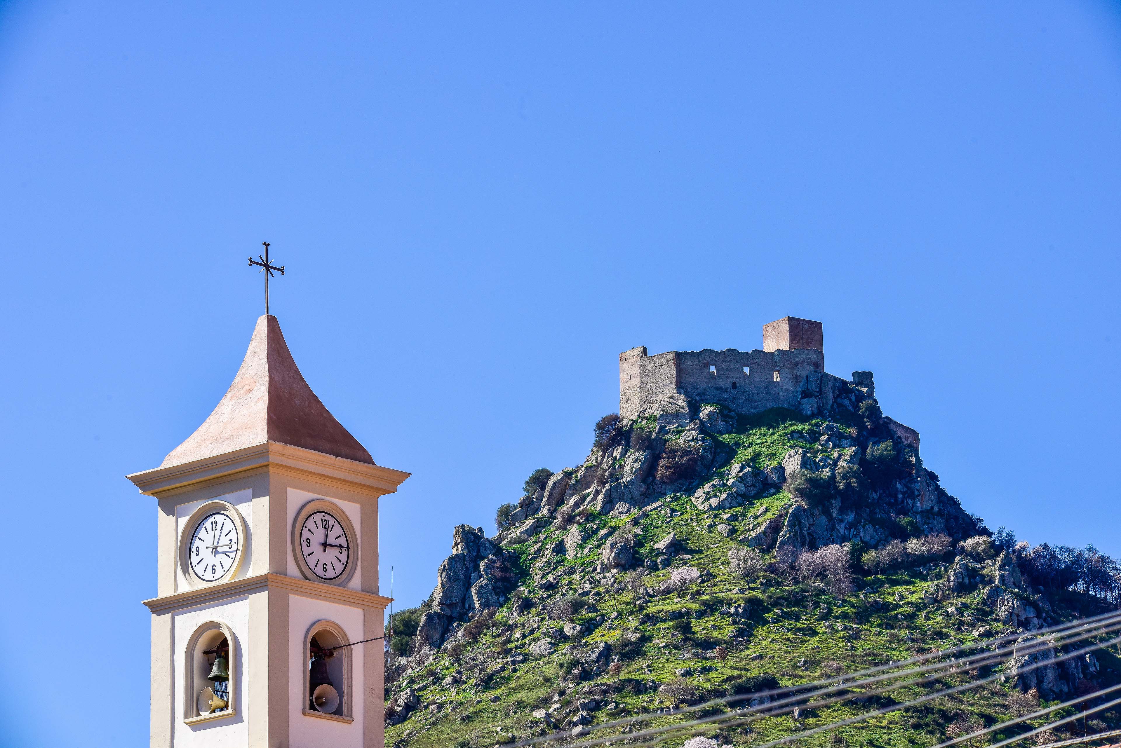 Particolare del campanile e il castello sullo sfondo (foto Ivo Piras)