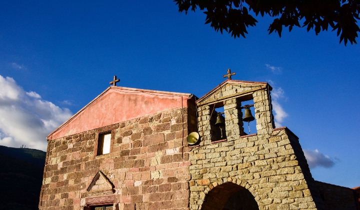 La facciata con portale architravato, finestrone rettangolare e campanile a vela biforato