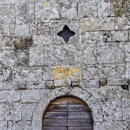 Particolari decori della facciata e della piccolissima finestrella cruciforme (foto Ivo Piras)