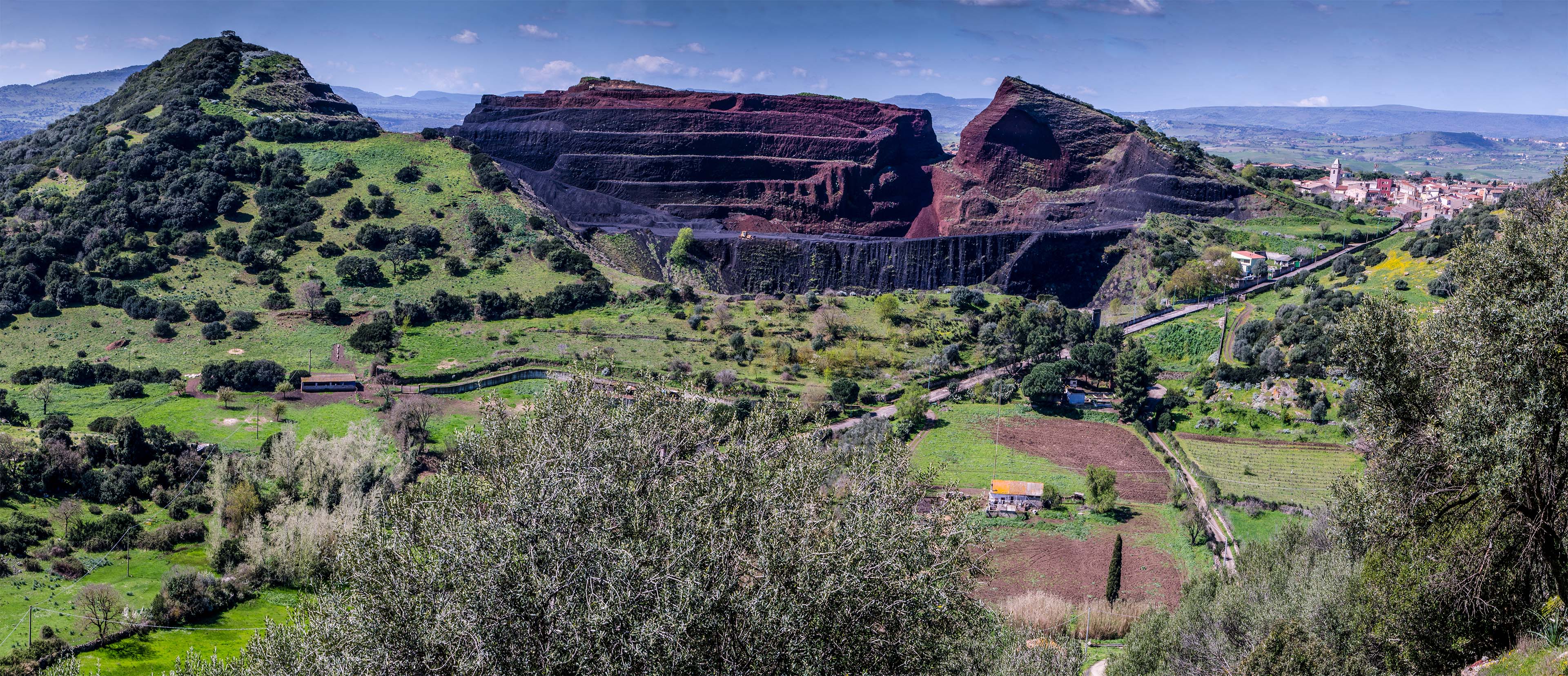 Il centro di Ittireddu con le cave di pietra rossa vulcanica da cui si estrae la estrazione la pomice (foto Giuseppe Lonis)