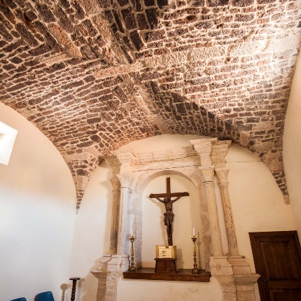 La zona absidale, a pianta quadrata, è conclusa da una volta a crociera e contiene un altare in pietra con colonne (foto Ivo Piras)