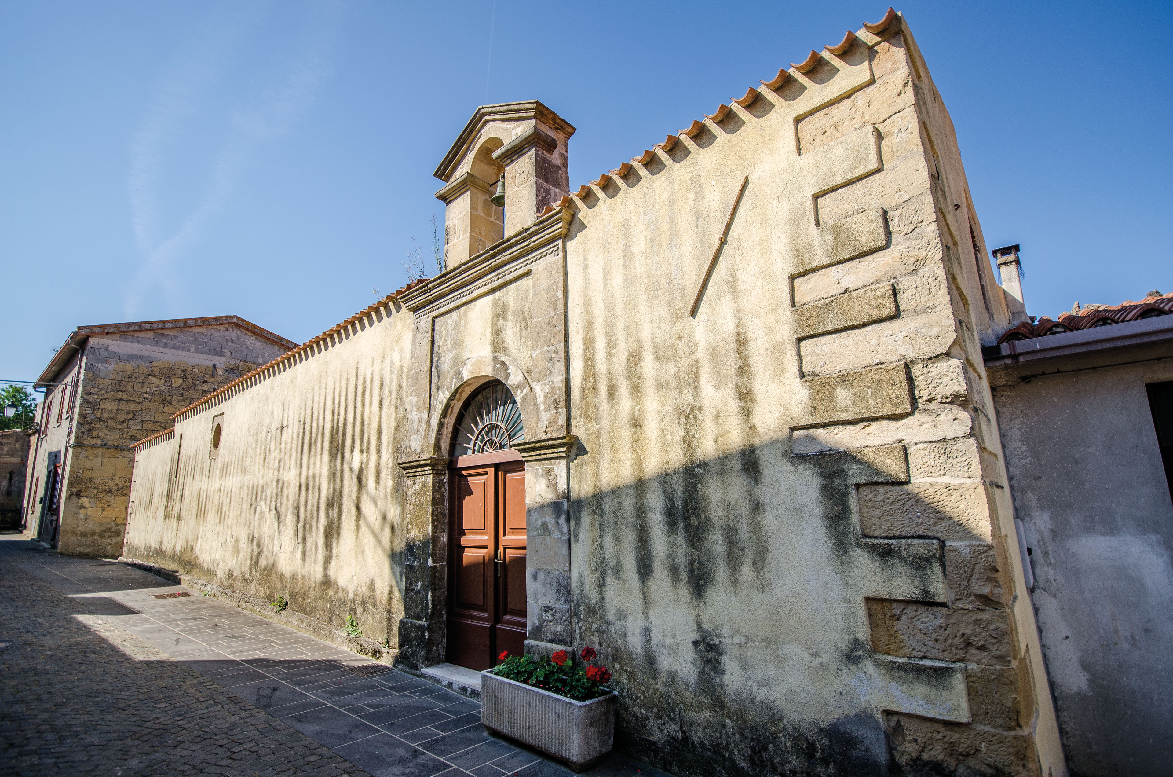 Il fronte esterno è caratterizzato dalla decorazione del portale in pietra calcarea di gusto rinascimentale e da un campanile a vela (foto Angelo Marras)