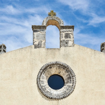 La facciata a spioventi presenta un campanile a vela e una finestrella circolare (foto Ivo Piras)