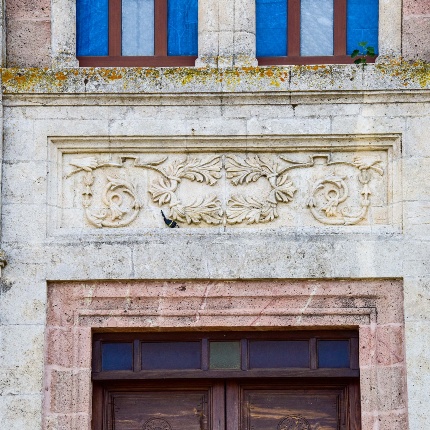 Un grande portone mediano incorniciato da conci in pietra chiara e sormontato da una architrave decorata (foto Ivo Piras)