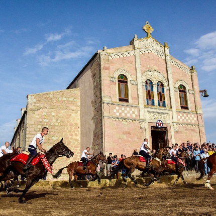 Un momento dell'Ardia, la corsa sfrenata a cavallo intorno alla chiesa, a rievocare la battaglia di ponte Milvio, dove Costantino sconfigge Massenzio (foto Ivo Piras)