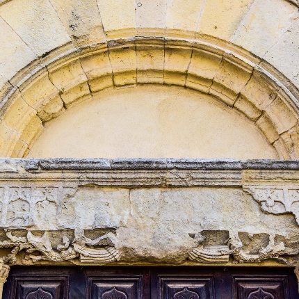Particolare dell'architrave del portone, con le sculture di Cristo con altri santi, ippogrifi ed altre rappresentazioni mostruose (foto Ivo Piras)