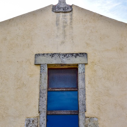 Particolare della facciata con la finestra rettangolare e la croce apicale (foto Ivo Piras)