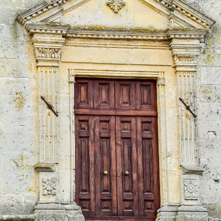 Il portale, architravato e timpanato, è abbellito ai lati da due lesene e stipiti ornati da un fascio di tre colonnine (foto Ivo Piras)