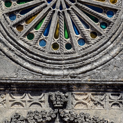 Il grande rosone con ghiera modanata, raggiera a bacchette piatte e spiraliformi che formano un delicato traforo a tondi e petali (foto Ivo Piras)