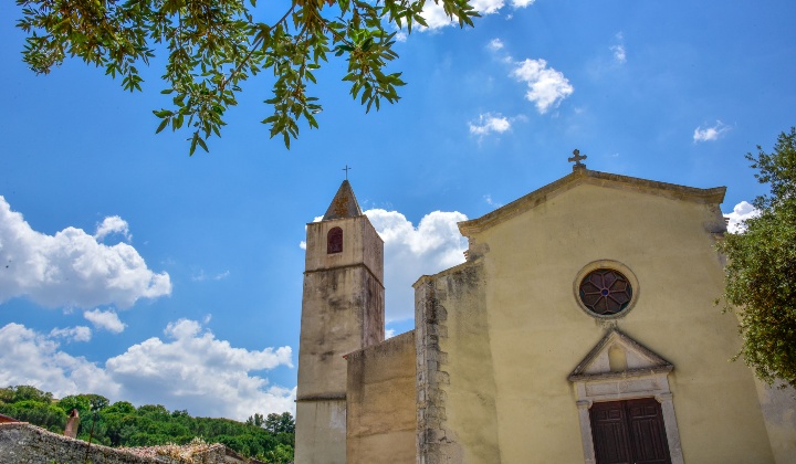 La facciata con linee semplici, portale timpanato sovrastato da un rosone, e copertura a doppio spiovente con croce apicale