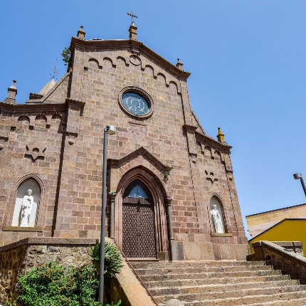 La chiesa, in stile romanico-pisano, è costruita in calda trachite scura (foto Ivo Piras)