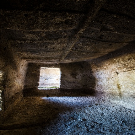 Tomba VIII, cella maggiore con soffitto scolpito e falsa porta sormontata da corna sulla destra (foto Giuseppe Lonis)